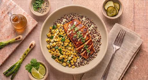 Cajun Salmon Bowl — Quinoa, zucchini, roasted corn, citrus aioli.